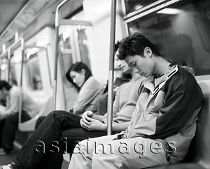 Asia Images Group - Young adults sleeping on train.