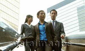 Asia Images Group - Male and female executives walking down stairs.