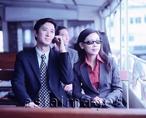 Asia Images Group - Male executive on cellular phone with female next to him, outdoors.