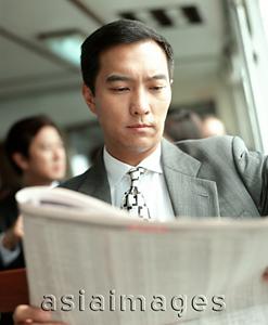 Asia Images Group - Male executive reading newspaper.