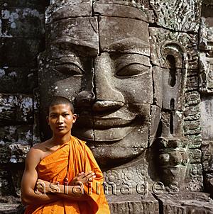 Asia Images Group - Cambodia, Ankor Thom, portrait of monk in front of the face of Avalokitesvara
