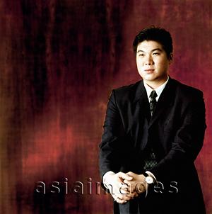Asia Images Group - Man in suit, sitting, portrait