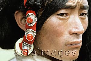 Asia Images Group - China, Szechuan (Sichuan), Kham region, A Khampa man wears traditional hair decorations.