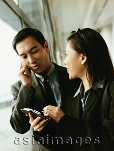 Asia Images Group - Executives using PDA and cellular phone.