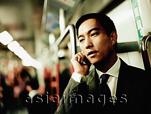 Asia Images Group - Executive using cellular phone in train.