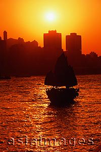 Asia Images Group - Hong Kong, Victoria Harbor, Silhouette of boat, sun in background.