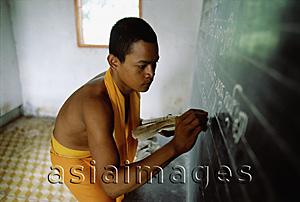 Asia Images Group - Vietnam, Mekong Delta region, Bac Lieu, Buddhist monk of Khmer origin writing on blackboard.