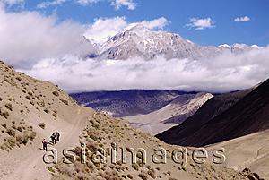 Asia Images Group - Nepal, Mustang, Tourists walking along high path, surrounded by mountains.
