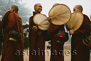 Asia Images Group - Myanmar (Burma), Bago, Smiling Buddhist monks with fans, collecting alms.