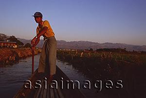 Asia Images Group - Myanmar (Burma), Inle lake, Boatman dressed in longyi steering canoe down backwaters.