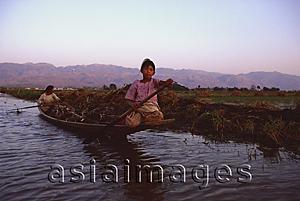 Asia Images Group - Myanmar (Burma), Inle lake, Women steering canoe filled with firewood.