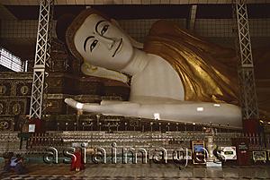 Asia Images Group - Myanmar (Burma), Bago, Shwethalyaung, Buddhist monk prays in front of reclining Buddha.