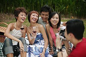Asia Images Group - Friends posing for pictures, holding wine glasses