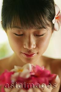 Asia Images Group - Portrait of a young woman, holding flowers