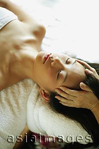 Asia Images Group - Young woman lying down on massage table