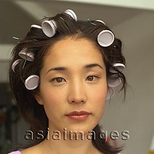 Asia Images Group - Young woman with curlers in hair, portrait