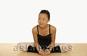Asia Images Group - Young woman in leotard sitting with legs folded.