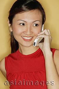Asia Images Group - Young woman wearing a red top, using a mobile phone