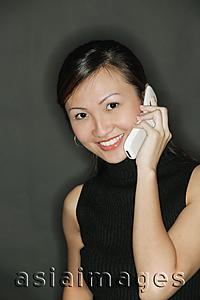 Asia Images Group - Young woman wearing a black top, using a mobile phone