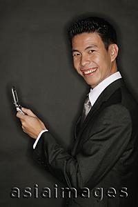 Asia Images Group - Young man holding mobile phone