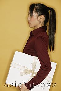 Asia Images Group - Young woman, side view, yellow background