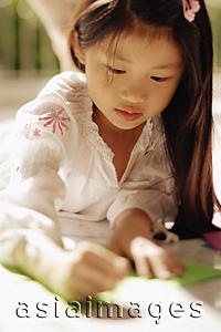 Asia Images Group - Young girl looking down, writing