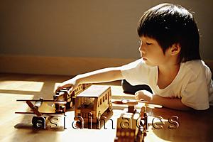 Asia Images Group - Young boy playing with toys, side view