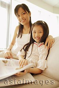 Asia Images Group - Mother and daughter, sitting side by side, looking at camera