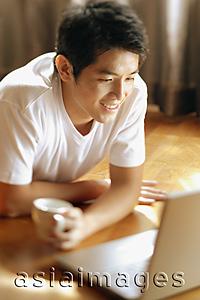 Asia Images Group - Young man looking at laptop,