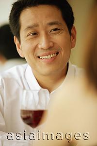 Asia Images Group - Man facing woman, glass of wine in front of him