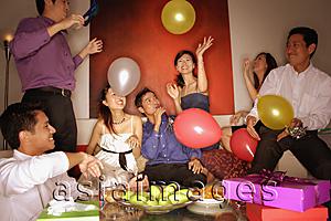 Asia Images Group - Group of friends having a party at home, playing with balloons