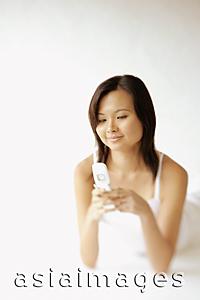Asia Images Group - Young woman lying on floor, using mobile phone