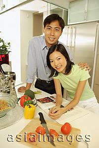 Asia Images Group - Young adults standing in kitchen, side by side, looking at camera