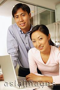 Asia Images Group - Young couple with laptop, looking at camera