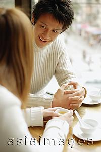 Asia Images Group - Young couple at a restaurant, talking, face to face