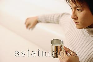 Asia Images Group - Young man sitting, holding coffee mug