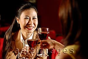 Asia Images Group - Two women toasting with wine glasses.