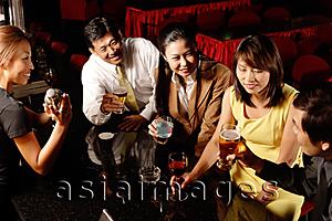 Asia Images Group - Couples drinking at bar, bartender shaking cocktail mixer