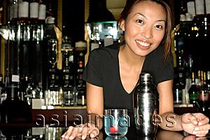 Asia Images Group - Bartender leaning on counter, looking at camera