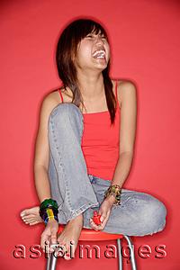 Asia Images Group - Young woman laughing, holding nail polish