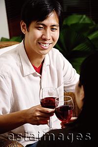 Asia Images Group - Couple toasting with wine glasses, man smiling