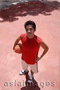 Asia Images Group - Man holding basketball, looking at camera