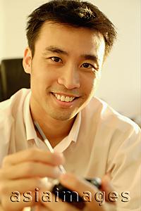 Asia Images Group - Executive using PDA, portrait