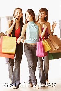 Asia Images Group - Young women with shopping bags, walking side by side