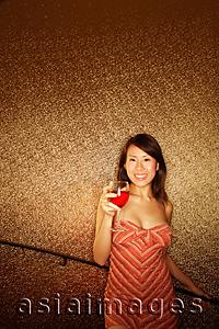 Asia Images Group - Young woman, holding wine glass, looking at camera