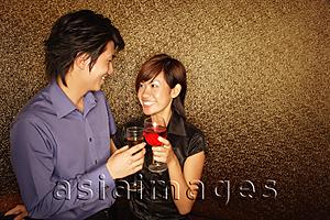 Asia Images Group - Couple toasting drinks, looking at each other