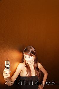 Asia Images Group - Young woman holding mobile phone, smiling