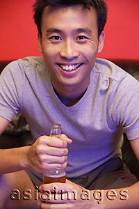Asia Images Group - Young man with beer bottle, looking at camera