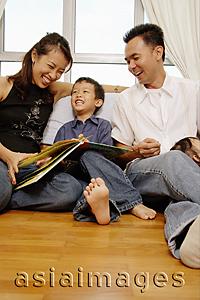 Asia Images Group - Family with one son sitting together, looking at book