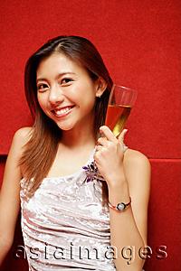 Asia Images Group - Young woman holding champagne glass, smiling at camera